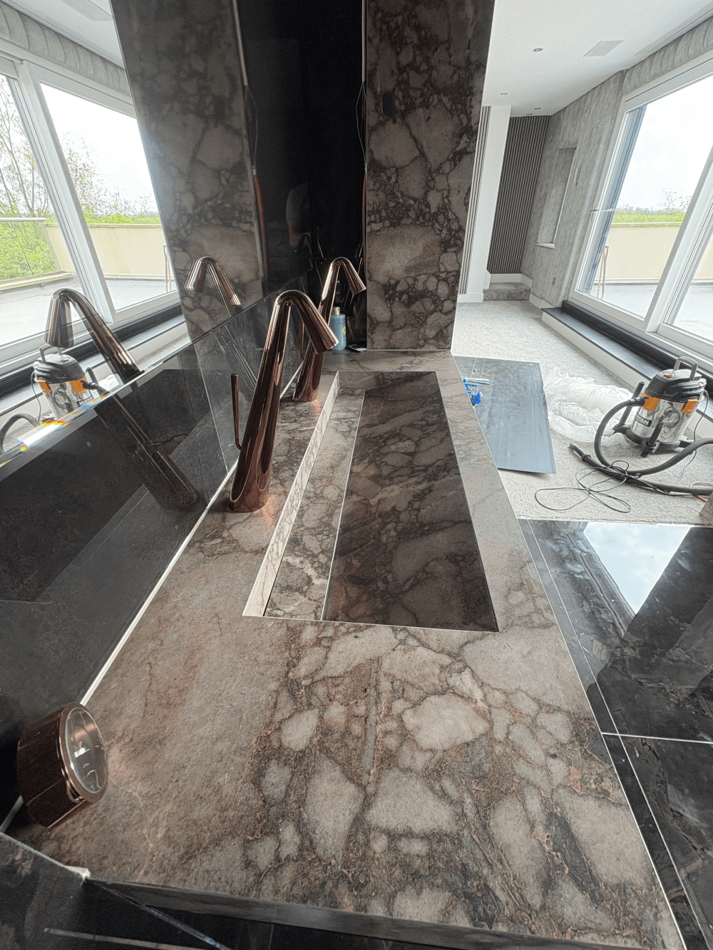 Stone trough basin in progress, corner pillar clad in matching slab